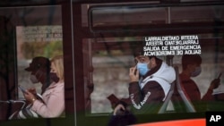 FILE - Passengers wearing face masks are seen on a bus in Bilbao, northern Spain, June 12, 2020. A county in Spain's northwestern region of Galicia has been placed on lockdown after several bars in the area reported new cases of the coronavirus.