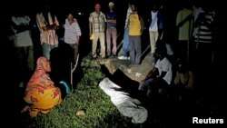 Relatives and friends gather around the covered body of Zedi Feruzi, the head of opposition party UPD, in Bujumbura, Burundi, May 23, 2015.