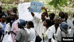 FILE - Zimbabwean riot policemen stand in front of doctors and nurses who are demonstrating over the deteriorating health system, in Harare, Nov. 18, 2008. On Monday, doctors went on strike for a second time in 2018, demanding better pay and working conditions.