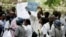 FILE - Zimbabwean riot police officers stand in front of doctors and nurses demonstrating over the deteriorating health system, outside Parirenyatwa public hospitals in Harare, Nov. 18, 2008.