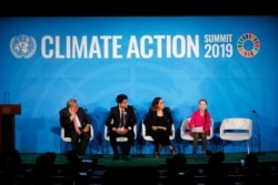 U.N. Secretary-General Antonio Guterres, far left, and young environmental activists look on as Greta Thunberg, of Sweden, in red, addresses the Climate Action Summit in the United Nations General Assembly, at U.N. headquarters, Sept. 23, 2019.