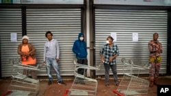 Residents of Yeoville neighborhood of Johannesburg, South Africa, wait in line to enter a grocery store, April 3, 2020. 
