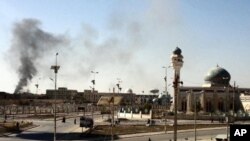 A plum of smoke is seen following a wave of attacks prior to the storming a police compound in the western Iraqi city of Ramadi, January 15, 2012.
