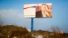 FILE - A partially damaged billboard with a portrait of Russian President Vladimir Putin is seen on a roadside near Simferopol, in Russia-annexed Crimea, Jan. 24, 2016. The billboard reads: "Crimea. Russia. Forever."