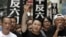 FILE - Xiong Yan flashes a victory sign during a march in Hong Kong marking the 20th anniversary of the military crackdown on a pro-democracy student movement in Beijing, May 31, 2009. 