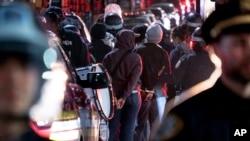 New York City police officers take people into custody near the Columbia University campus in New York April 30, 2024, after a building taken over by protesters earlier in the day was cleared, along with a tent encampment.