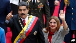 El presidente de Venezuela, Nicolás Maduro, y la primera dama Cilia Flores, saludan a los medios cuando llegan a una sesión con la Asamblea Constituyente en Caracas, Venezuela. 