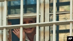 Former Ukrainian Prime Minister Yulia Tymoshenko waves from a prison window in Kyiv, Nov. 4, 2011.