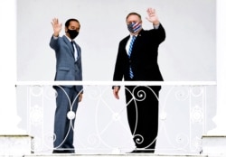 In this photo released by Indonesian Presidential Palace, Indonesian President Joko Widodo, left, and U.S. Secretary of State Mike Pompeo wave to photographers at Bogor Presidential Palace in Bogor, West Java, Indonesia, Oct. 29, 2020.