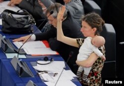 Anggota Parlemen Eropa Anneliese Dodds dari Inggris menggendong bayinya saat mengikuti sesi pemungutan suara di Parlemen Eropa di Strasbourg, Prancis, 14 April 2016. (Foto: Reuters)
