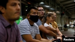 FILE - Sayed Abdul Wase Majidi's older brother holds his daughter while he waits for his younger brother to arrive from Fort Lee, Va., in Sacramento, Calif., Aug. 5, 2021. Majidi was a former Afghan interpreter brought earlier to the United States.