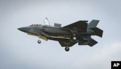 FILE - The F-35 Lightning II hovers in front of crowds during its first solo appearance at the Farnborough Air Show in the United Kingdom, July 12, 2016.