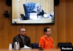 Defendant Larry Nassar, right, and his defense attorney Matt Newburg listen to Judge Janice Cunningham hand down his prison sentence during the sentencing hearing of Nassar, a former team USA Gymnastics, in the Eaton County Court in Charlotte, Michigan.