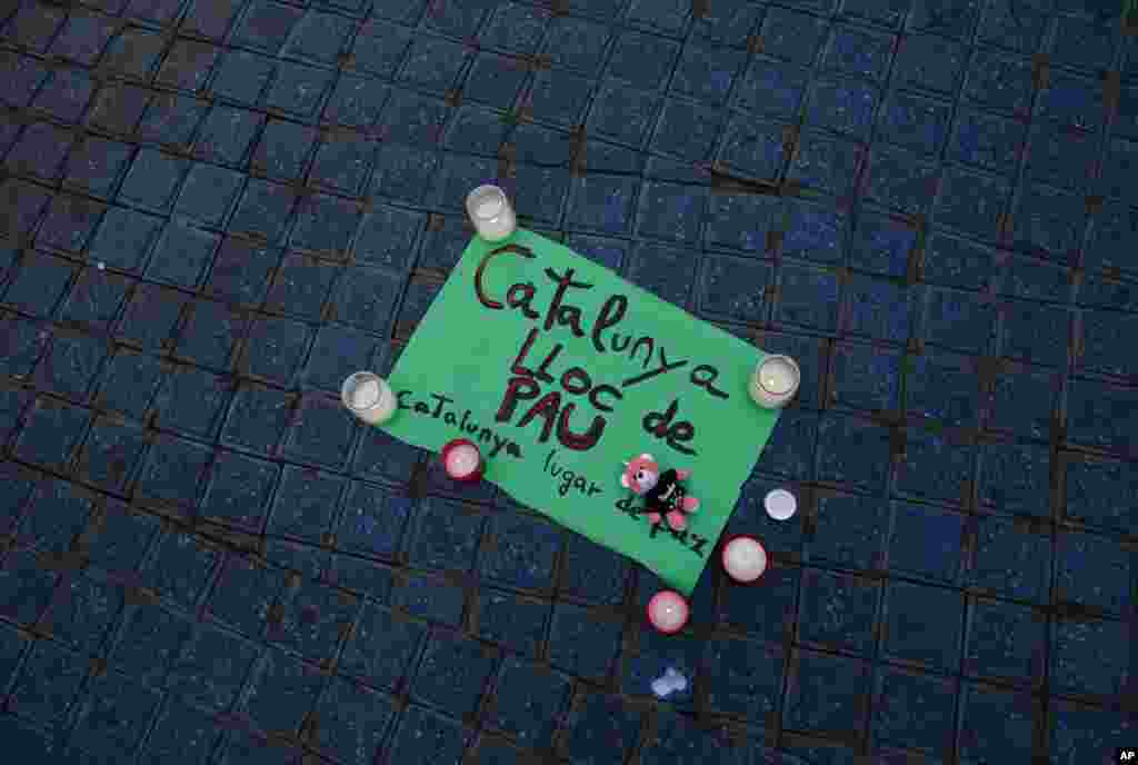 A paper that reads "Catalunya &mdash; place of peace" is placed along with candles on the pavement in Las Ramblas, Barcelona, Spain, Aug. 18, 2017. Spanish police said the manhunt intensified for the perpetrators of Europe's latest rampage claimed by the Islamic State.
