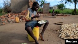 Bernado Jofresse, 14, eats rice for breakfast as he sits beside his family's damaged house in the aftermath of Cyclone Idai, in the village of Cheia, which means "Flood" in Portuguese, near Beira, Mozambique, April 3, 2019.