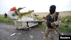 A Russia-aligned fighter standing at the crash site of Malaysia Airlines flight MH17, near the settlement of Grabovo in the Donetsk region, on July 18, 2014. (Maxim Zmeyev/Reuters)