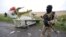 A Russia-aligned fighter standing at the crash site of Malaysia Airlines flight MH17, near the settlement of Grabovo in the Donetsk region, on July 18, 2014. (Maxim Zmeyev/Reuters)