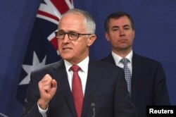 Australian Prime Minister Malcolm Turnbull speaks as Australia's Minister for Justice Michael Keenan listens on during a media conference in Sydney, Australia, July 30, 2017.