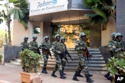 Soldiers from the presidential guard patrol outside the Radisson Blu hotel in Bamako, Mali, in anticipation of the president's visit, Nov. 21, 2015. Islamic extremists armed with guns and grenades stormed the luxury Radisson Blu hotel in Mali's capital Fr
