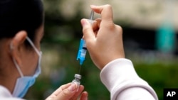 FILE - A shot of the Pfizer COVID-19 vaccine is prepared at the First Baptist Church of Pasadena, California, May 14, 2021.