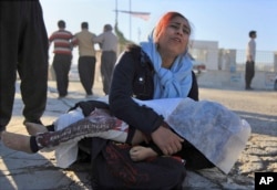 A woman mourns as she holds the body of her daughter, who died in an earthquake, in Sarpol-e-Zahab, western Iran, Nov. 13, 2017.