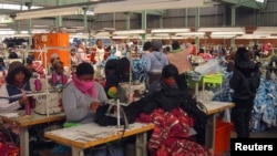 Workers work on machines at a clothing factory at an industrial town of Newcastle, 260 km (162 miles) southeast of Johannesburg, May 8, 2013.