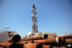 FILE - Drilling tubing is piled next to a drilling site in the Unity oil field, South Sudan, in 2010.