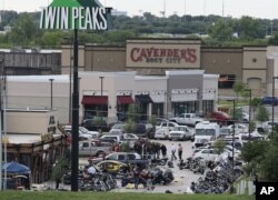 FILE - Authorities investigate a shooting in the parking lot of Twin Peaks restaurant in Waco, Texas. An indictment announced by the U.S. Attorney's Office in San Antonio accuses three Bandidos leaders of sanctioning a three-year fight that included viole