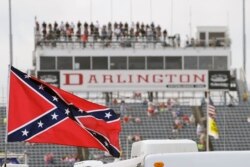 FILE - In this Sept. 5, 2015, file photo, a Confederate flag flies before a NASCAR race at Darlington Raceway in Darlington, S.C. Bubba Wallace, the only African-American driver in NASCAR, calls for a ban on the Confederate flag.