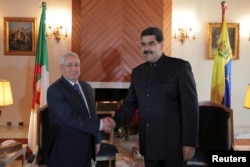 Venezuela's President Nicolas Maduro, right, shakes hands with Algeria's Senate President Abdelkader Bensalah during their meeting in Algiers, Algeria, Sept. 11, 2017.