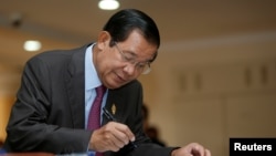 Cambodia's Prime Minister Hun Sen signs a register as he arrives before a plenary session at the National Assembly of Cambodia, in central Phnom Penh, Oct. 12, 2017.