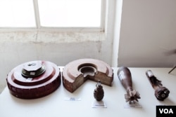 FILE - A portable display teaches children and farmers what landmines and hand grenades look like. (U. Filimonova/VOA)