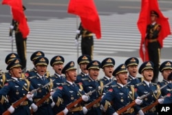 Members of an honor guard shout as they march in formation during a welcome ceremony for visiting U.S. President Donald Trump outside the Great Hall of the People in Beijing, Nov. 9, 2017.