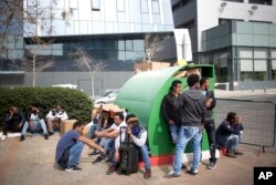 In this Wednesday, Feb. 7, 2018 photo, African migrants gather during a protest in front of the Rwanda embassy in Herzeliya, Israel.