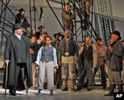 Ben Heppner as Captain Ahab (left) encourages his crew to keep a sharp eye out for the white whale, Moby Dick.