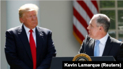 El presidente estadounidense Donald Trump (L) escucha al administrador de EPA Scott Pruitt después de anunciar su decisión de que Estados Unidos se retirará del Acuerdo Climático de París, en el Rose Garden de la Casa Blanca en Washington, EE. UU.