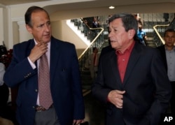 FILE - Colombian government representative Juan Camilo Restrepo, left, speaks with ELN rebel leader Pablo Beltran after giving a joint press conference announcing the signing of a cease-fire, in Quito, Ecuador, Sept. 4, 2017.