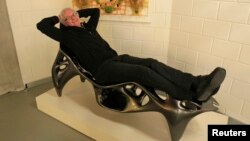Wilfried Vancraen, chief executive of Materialise, poses for Reuters on a 3D KOL/MAC Root Chair by Sulan Kolatan and William MacDonald, built in one piece on Materialise's Mammoth Stereolithography Machine, in Leuven, January 24, 2013.