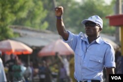 After a three-week training course, 22-year-old Bashir mans a check-point, searching cars for weapons one-by-one in Maiduguri, Nigeria, Dec. 1, 2013. (Heather Murdock for VOA)