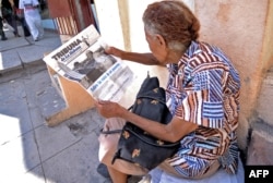 A woman reads 'Tribuna de la Habana' newspaper in central Havana a day before the visit of Pope Francis to Cuba on Sept. 18, 2015.