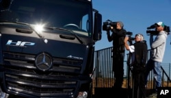 FILE - TV crews film the Actros autonomous truck by Mercedes-Benz near Stuttgart, Germany, Oct. 2, 2015.
