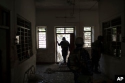 Federal policemen inspect the interior of a house as fighting against Islamic State militants continues on the western side of Mosul, Iraq, March 29, 2017.