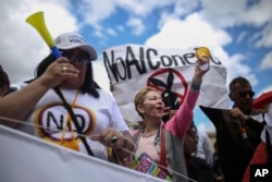 FILE - Opponents of peace agreements between rebels of the Revolutionary Armed Forces of Colombia, FARC, with the government gather outside the congress in Bogota, Colombia, Nov. 30, 2016.