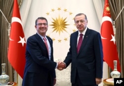 FILE - Turkey's President Recep Tayyip Erdogan, right, and U.S Secretary of Defense Ash Carter shake hands before a meeting in Ankara, Turkey, Oct. 21, 2016.