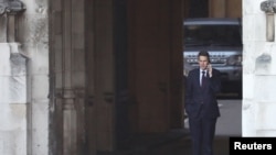 FILE - Britain's Secretary of State for Defense Gavin Williamson speaks on his mobile phone inside the Houses of Parliament in London, Britain, Dec. 12, 2018.