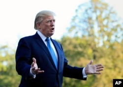 President Donald Trump speaks to reporters upon his return to the White House in Washington.