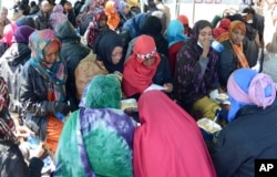 Migrants receive food after disembarking from the Italian Navy vessel 'Chimera' in Salerno, Italy, April 22, 2015.