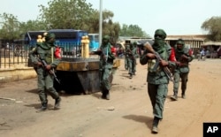 Malian troops join with former rebels during a joint patrol in Gao, Mali, Feb. 23, 2017. A joint battalion of 600 people is the first to formally combine Malian soldiers with the rebels from armed independent groups of the Azawad region that signed a 2015 peace agreement.