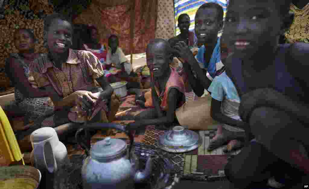 A family makes tea outside their makeshift shelter at a United Nations compound, Juba, South Sudan, Dec. 31, 2013.