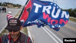 A supporter of former President Donald Trump attends a gathering outside his Mar-a-Lago resort after he posted a message saying he expects to be arrested and called on his supporters to protest, in Palm Beach, Florida, March 20, 2023.